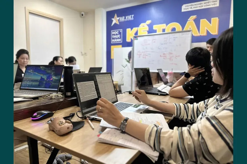 Học viên thực hành với laptop, tài liệu và sổ ghi chép